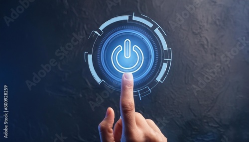 Close-up of a finger pressing a glowing blue power button on a dark background 
