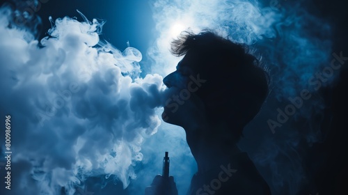 A young man is exhaling a cloud of smoke from his mouth
