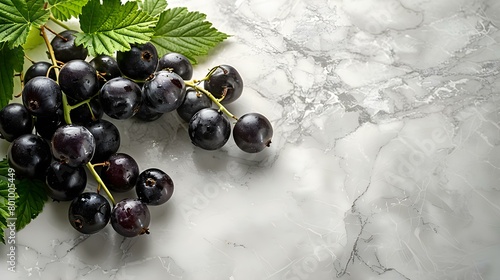 Blackcurrants lie on the white marble countertop
