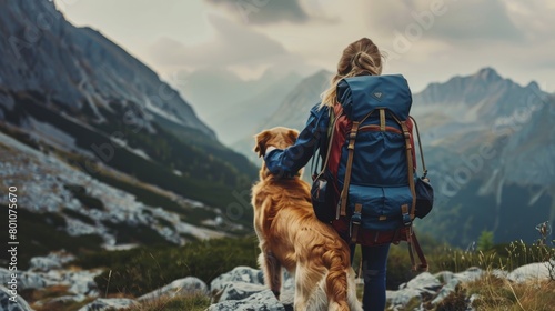 girl hiking with her golden retriever dog in the mountains