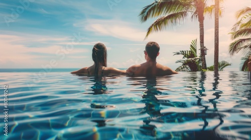 Traveler couple with sunhats hugging in infinity pool and enjoyinf the view to sea