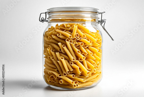 Transparent storage jar with wholegrain pasta with gluten on white isolated background. Transparent plastic container with lid for store food and bulk product. Pasta in jar for store. Copy space