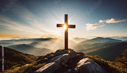 a christian cross on top of a mountain with a shinin