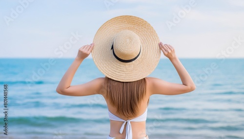  young woman wearing straw hat on the seashore