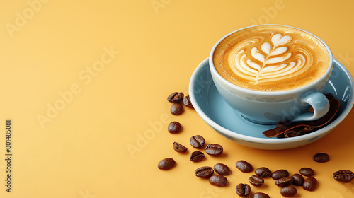  A cappuccino in a mug on a yellow-colored plate with scattered coffee beans