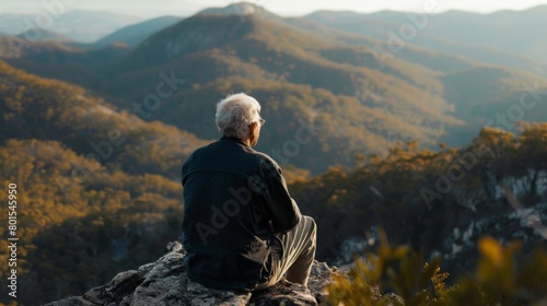 Elderly man enjoying a scenic view from a mountain lookout