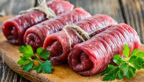 fresh raw beef roulades on wooden table
