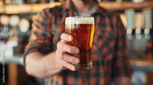 A man holds a pint of a zeroalcohol IPA with a label that proudly boasts the beers low calorie and sugar content.