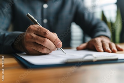 Close-up of a hand signing a formal document with a sophisticated fountain pen, depicting business agreements.