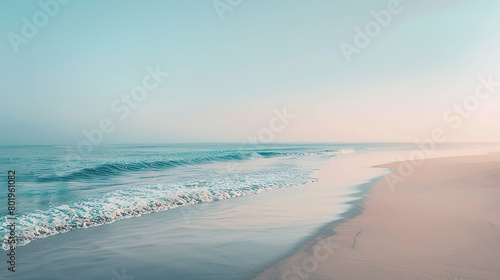 Beach scene at sunrise, waves lapping onto the smooth and undisturbed sandy shore, blue sky blending into the sea.
