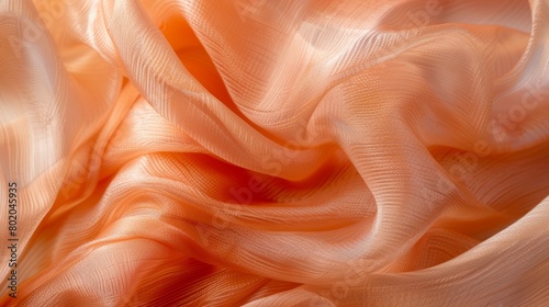 The smooth almost weightless texture of a silk scarf in a soft peach hue..