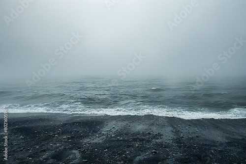 Foggy seascape with black sand beach and waves