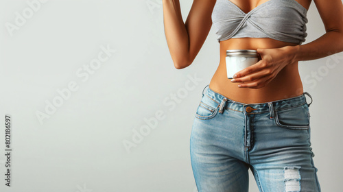 Beautiful young woman in loose jeans and with jar 