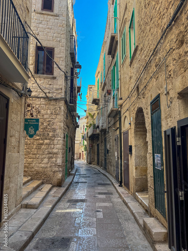 An old town street in Puglia, Italy under a brilliant blue sky