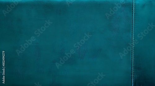 A close-up texture shot of teal-colored leather material with a visible seam line