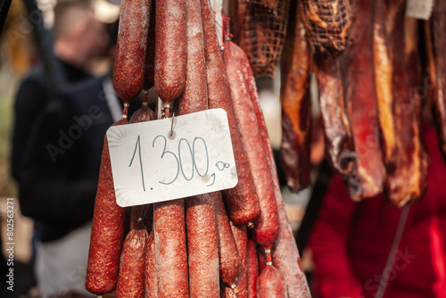 Selective blur on cajna kobasica sausages spiked for sale with a price of 1300 on stand of a serbian market. Cajna kobasica, or tea sausage, is a traditional serbian sausage made of smoked cured pork.