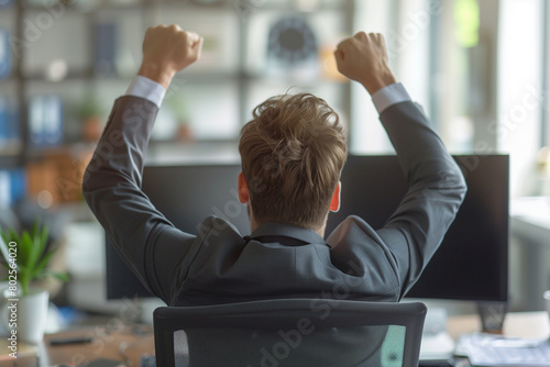 Man Sitting at Desk Raising His Arms