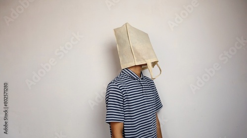 young Asian man wearing a shopping bag on his head