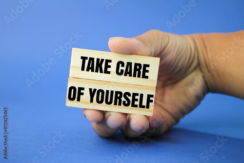 hand holding a stick with the words take care of yourself. the concept of self-care