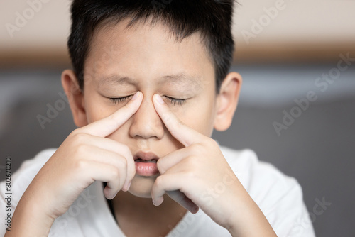 Child boy suffering chronic Rhinosinusitis,Rhinitis or acute Sinusitis,pain in nasal cavity,nose bridge sore,aching eye socket,sinus infections,nasal congestion,difficult to breathe through nostrils