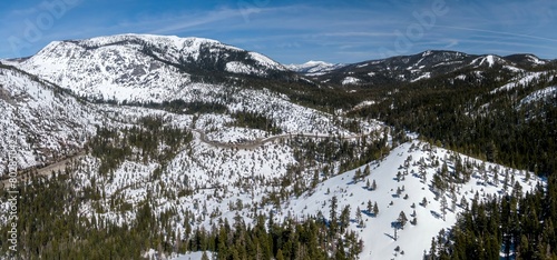 Aerial: Snow covered Mountains and forest in the sierra Nevada ranges Twin Bridges, California, United States of America.