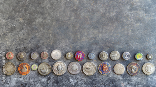 A row of coins with a variety of designs and colors