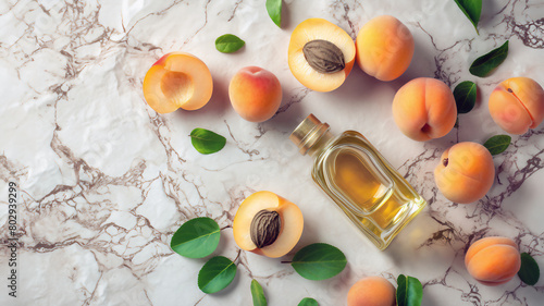 Top view of a pure apricot kernel oil in a clear bottle, flanked by fresh apricots, their kernels, and leaves against a marbled background. Concept of natural cosmetics ingredients, healthy cooking