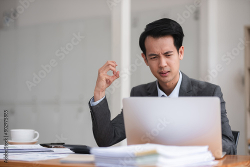 Unhappy young businessman feeling bored or disappointed while sitting in the office Distracted male employee feeling tired from monotonous work