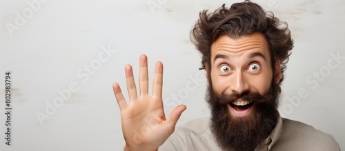 A bearded man enthusiastically announces a discounts sale with copy space image on a beige background while greeting someone hello