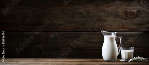 A copy space image depicting a jug of milk placed elegantly on a rustic dark wooden table
