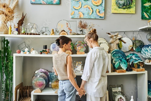 Two women, a loving lesbian couple, stand together in an art studio, sharing a tender moment.