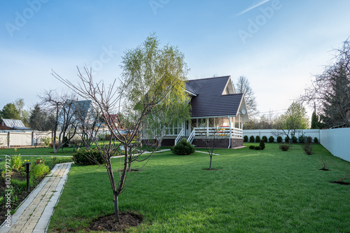 Russian dacha with cottage, garden, vegetable garden, lawn and footpaths.