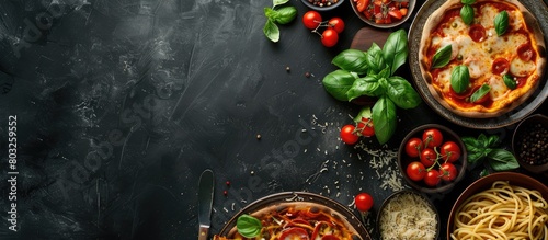 Italian cuisine on a dark backdrop featuring pasta and pizza from a top angle with empty space for text.