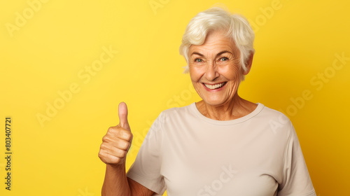 A blonde elderly woman winking and giving a thumbs-up, casual and confident.