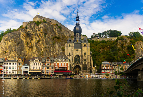 Picturesque view of Collegiate Church of Notre Dame on embankment of Meuse river and Citadel of Dinant on cliff, Belgium