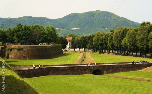 Mura di antica città Lucca, con ponte e prato verde davanti, Toscana, Italia