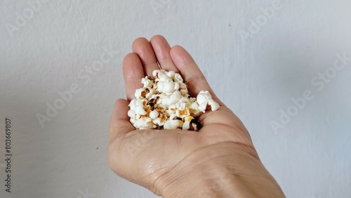 person holding a handful of popcorn