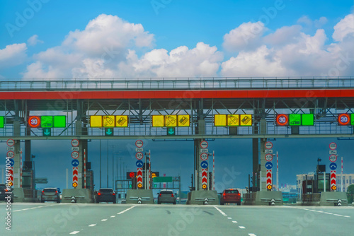 Entrance to the toll road, limited by the barrier. Cashless payment transponder, speed limit signs