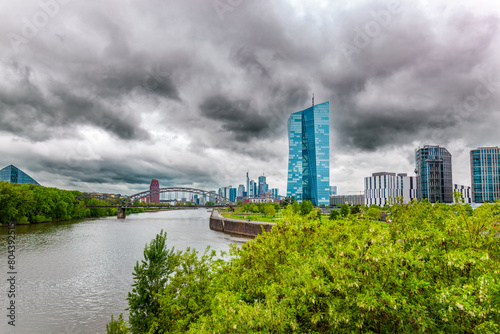 View of the River Main with the European city skyline, financial centre of Frankfurt. Skyscraper buildings in Germany on overcast, Storm, dramatic sky Background. Business and finance concept