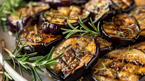 A platter of grilled eggplant seasoned with rosemary, ready to be served.