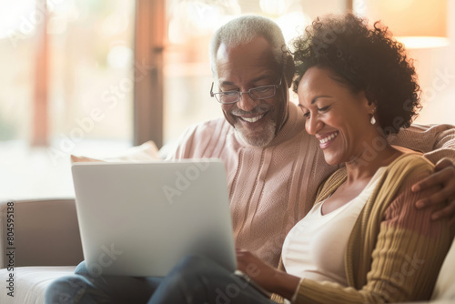 Brimming with happiness, a mature couple enjoys a serene moment together at home, each using their laptop, reflecting their shared joy, connection to technology, and loving partnership in retirement.