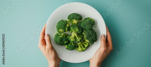 Photo of Steamed broccoli on white plate / isolated on clear background, top view shot, food photography