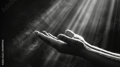 Open hands gently catching sunbeams in a serene, black and white photograph, symbolizing hope, faith, and spiritual enlightenment