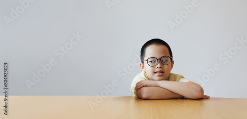 The cute boy with glasses, looking intelligent, strikes a pose of hugging himself and gazes off to the side. isolated on white background.