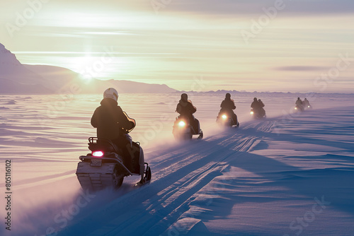 people on snowmobiles crossing a snowy landscape during a stunning sunset, creating long shadows on the terrain