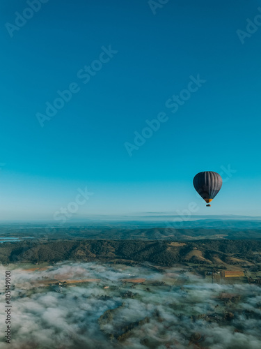 Black hot-air balloon flying over the mountain, awesome landscape view, Melbourne, Australia, Yarra Valley. 