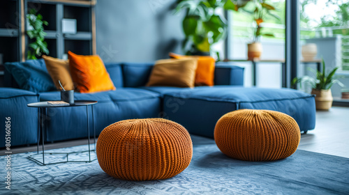 A pair of fabric-covered ottomans positioned adjacent to a deep blue sectional sofa. This reflects the Scandinavian aesthetic in a contemporary living space