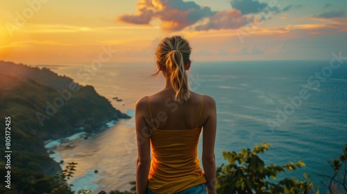 Woman of 20 years old standing on edge of mountain, watching the sea