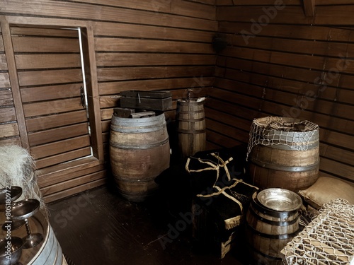 Interior cargo bay area of a wooden historical ship with barrels and ropes, Nao Victoria replica