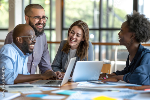 A diverse group of businesspeople were working together in an office, smiling and discussing over a laptop computer on a table